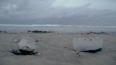 Sahildeki çöpler, arka plandaki plastikler okyanus.