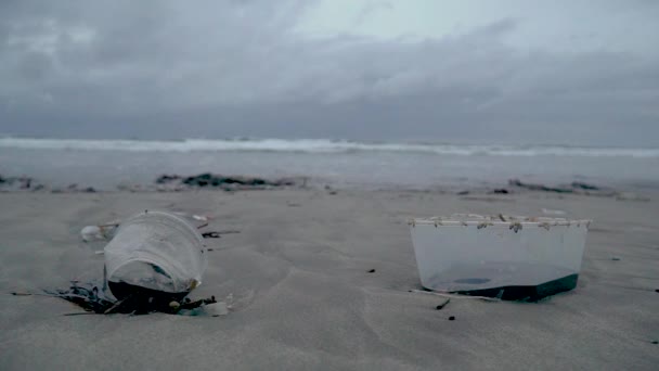 Мусор на пляже, пластик на заднем плане океан — стоковое видео