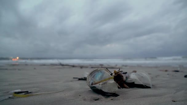Lixo na praia, plástico no fundo o oceano passa por uma mulher — Vídeo de Stock