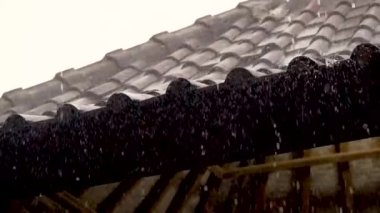 Ağır yağmur Asya 'da ağır çekimde bir fayanstan çatıya yağıyor.