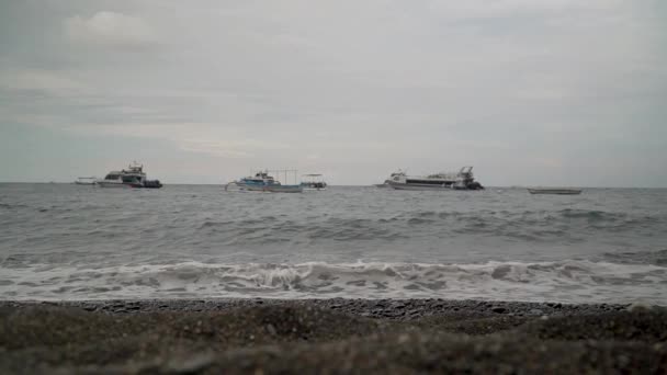 Onde oceaniche che si infrangono sulla spiaggia sullo sfondo navi Bali Indonesia — Video Stock