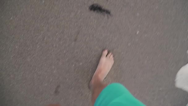 A man walks along the beach in the frame only legs top view sand and waves — Stock Video