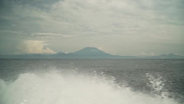 Het uitzicht van de boot venster op de Agung vulkaan, vliegende bruzgi slow motion — Stockvideo