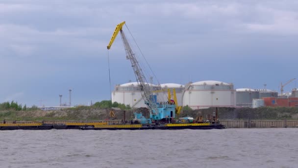 La grue fonctionne, sort le seau de l'eau de l'eau et le renverse ailleurs — Video