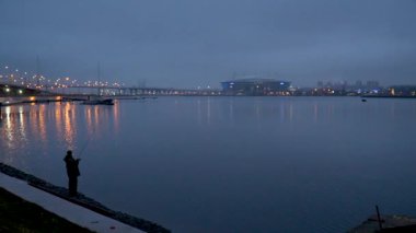 Balıkçı St. Petersburg 'daki Neva Nehri' nde balık yakalar.
