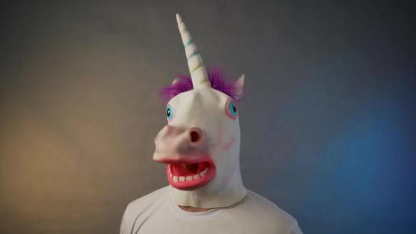 El hombre con la máscara del unicornio sacude la cabeza — Vídeo de stock
