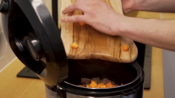 A man cooks the beef, add the carrot into the dish — Stock Video