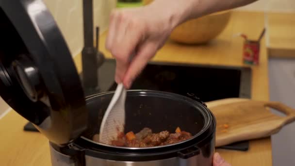 Male stir beef in a slow cooker — Stock Video