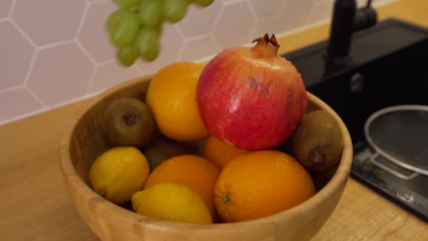 Un homme a lavé un bouquet de raisins et les a mis sur le plateau de fruits — Video