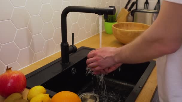 Чоловік миє апельсини під проточною водою — стокове відео