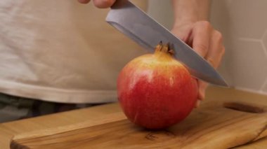 Adam kesim tahtasıyla nar kesiyor.