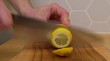 Adam dilimlenmiş limon dilimleri kesiyor.
