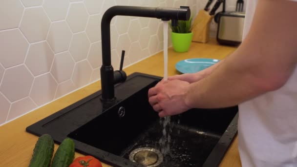 Een man wast onder stromend water de tomaten — Stockvideo