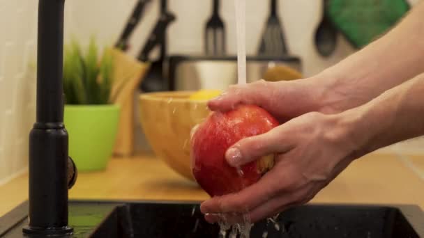 Een man wast zich onder stromende watergranaten — Stockvideo