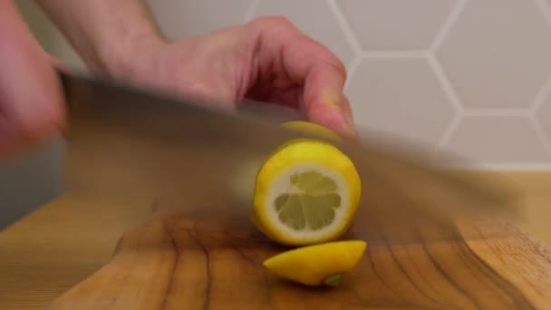 Человек режет ломтики лимона на разделочной доске — стоковое видео