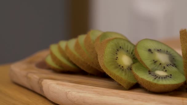 Kiwi rebanadas tumbado en la tabla de cortar — Vídeos de Stock