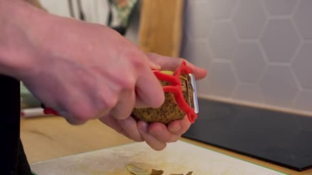 Man skalning potatis med en speciell kniv — Stockvideo