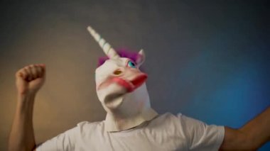 Maskeli adam. Tek boynuzlu at başını sallıyor.