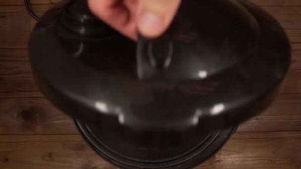 Un hombre cocina estofado de ternera, abre la tapa de la olla de cocción lenta — Vídeos de Stock