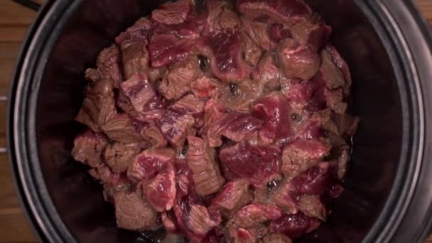 Um homem cozinha ensopado de carne, abre a tampa do fogão lento — Vídeo de Stock