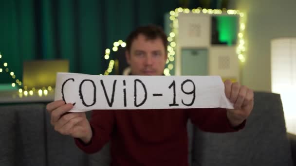 Człowiek rozwija rolkę papieru toaletowego, na którym jest napisane covid-19 i rozrywa go — Wideo stockowe