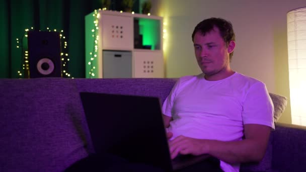 Mann liegt mit Laptop auf Sofa — Stockvideo