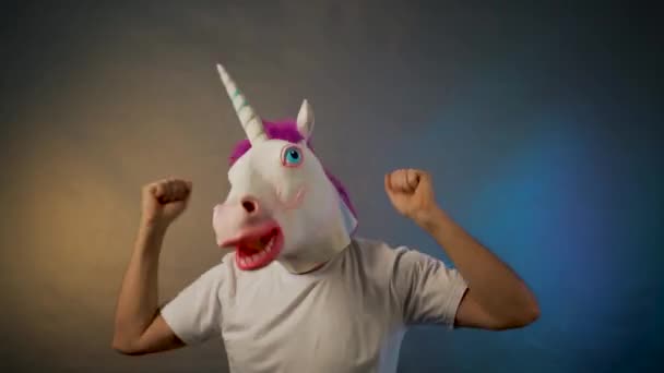 El hombre bailando en la máscara de unicornio sobre fondo gris — Vídeo de stock