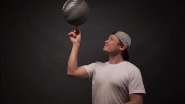 Adam gri arka planda parmak basketbolunu açıyor.