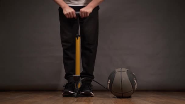 Man pompt een basketbal pomp — Stockvideo