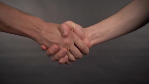 Двое мужчин пожимают руки крупным планом — стоковое видео