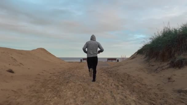 Der Mann rennt ans Meer am Strand — Stockvideo