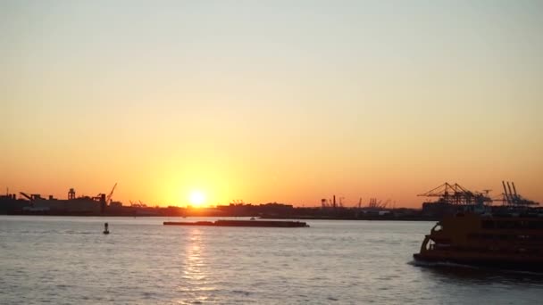 New York, USA - 13 september 2017: De veerboot vaart bij zonsondergang langs de rivier — Stockvideo