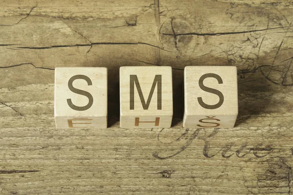 木製の背景上の sms の単語 — ストック写真