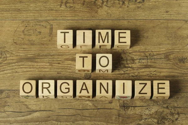 time to organize text on wooden cubes on a wooden background
