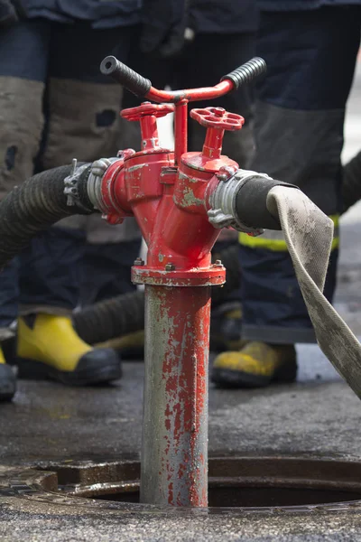 Red fire hydrant water pipe near the road. Fire hidrant for emergency fire access — Stock Photo, Image