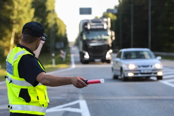 拉脱维亚警察在高速公路上指挥交通 图库照片