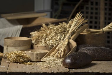 Ekmek arka plan. Kahverengi tam tahıl somun kompozisyon buğday kulaklı rustik ahşap üzerine dağılmış