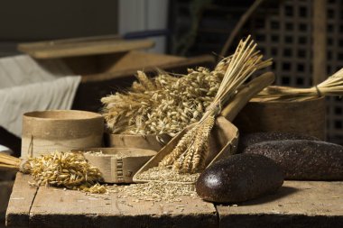 Ekmek arka plan. Kahverengi tam tahıl somun kompozisyon buğday kulaklı rustik ahşap üzerine dağılmış