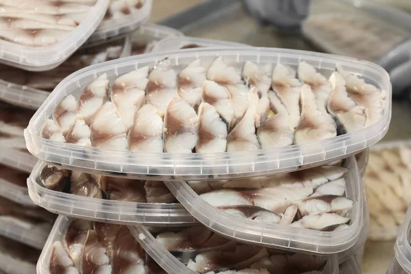 用植物油腌制的腌制大西洋鲱鱼片塑料容器 图库图片