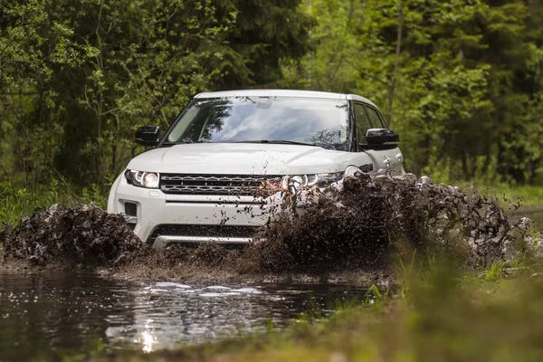 Scene of mud splash in off-road racing. Dirty off road trip. Dirty full of mud SUV Type car right after crossing river