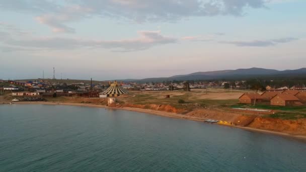 Lake Baikal, Olkhon Island. Video shooting. The drone is flying over the lake going down. View of the village and the roofs of the houses. — Stock Video