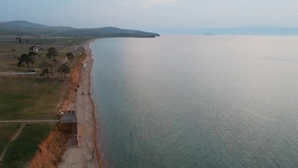 Lago Baikal, Ilha Olkhon. Gravação de vídeo. O drone está voando ao longo da costa. Vista do lago e praia arenosa . — Vídeo de Stock