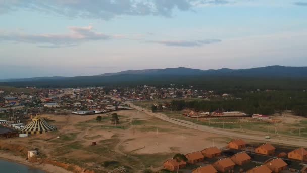 Baikalsee, Insel Olchon. Videodreh. Die Drohne fliegt über den See. Blick auf das Dorf und die Dächer der Häuser. — Stockvideo