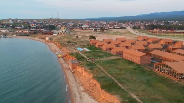 Baykal Gölü, Olkhon Adası. Video çekimi. İnsansız hava aracı göl kıyısında uçuyor. Köyün manzarası ve evlerin çatıları.. — Stok video