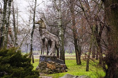 Boş bir sonbahar parkında terk edilmiş eski bir anıt.