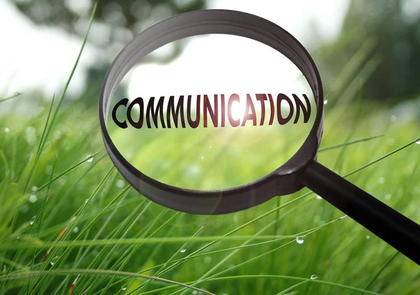 Magnifying glass with the word communication on grass background. Selective focus — Stock Photo, Image