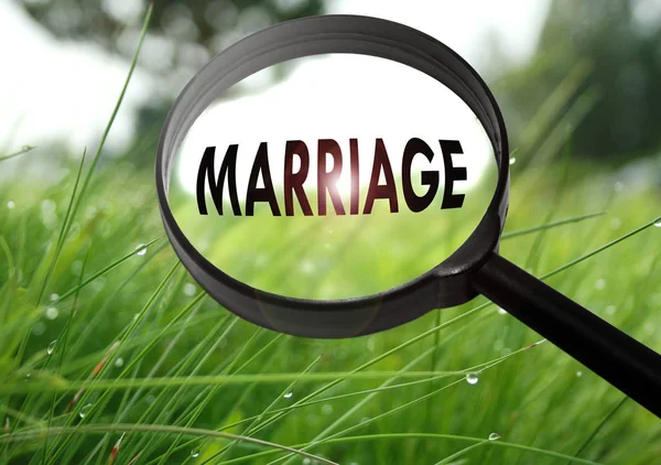 Lupe mit dem Wort Ehe auf Grashintergrund. Selektiver Fokus — Stockfoto