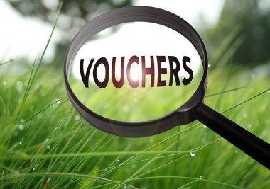 Çim zemin üzerinde kelime kuponları ile Büyüteç. Seçici odak