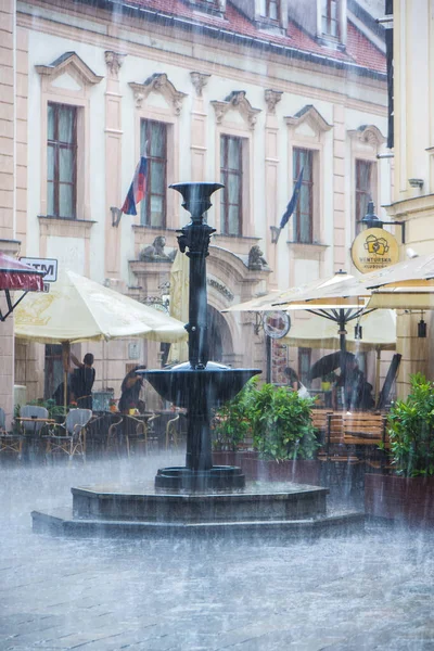 Forte pioggia in piazza del centro storico a bratislava Foto Stock