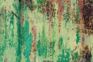 Zıplayan, çatlak boyalı paslı yeşil-sarı bir çarşaf. Soyut renkli doku arkaplanı.